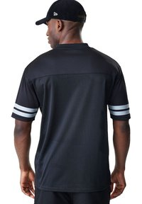 Jersey nero a maniche corte con schiena in rete, caratterizzato da strisce grigie sulle maniche, scollatura rotonda e texture liscia.