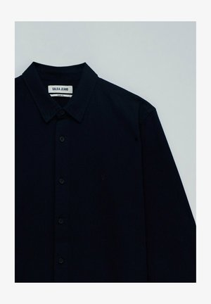 Uska slim fit tamno plava košulja s kopčanjem, od rebraste tkanine, s kragnom i oznakom brenda na izrezu. Šest dugmadi sprijeda.