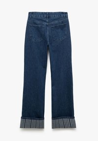 Jeans de mezclilla azul oscuro con corte recto, bolsillos traseros y un dobladillo con puño gris a rayas, que muestran una rica textura.