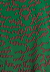 Tissu vert avec des formes noires irrégulières remplies de rayures verticales roses créant un motif abstrait audacieux.