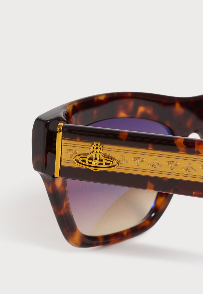 Tortoiseshell sunglasses arm with gold-tone Vivienne Westwood orb logo and gradient purple lenses visible through the frame.