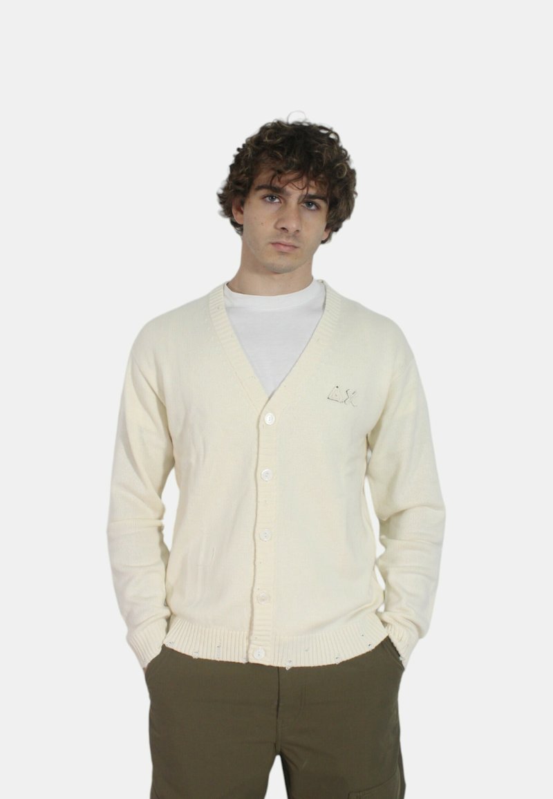 Cardigan di crema chiara in maglia testurizzata, design a scollo a V, cinque bottoni, polsini e orlo a coste, con un sottile dettaglio ricamato.