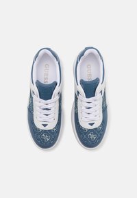 Sneaker in denim blu con dettagli bianchi, caratterizzati da un motivo con logo, lacci spessi e suola imbottita. Materiali in poliuretano e tessuto.