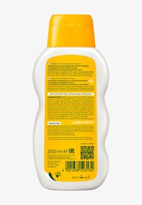 Biały, owalny plastikowy buteleczka z żółtą nakrętką z klapką. Etykieta zawiera tekst w wielu językach oraz kod QR. Zawiera 200 ml lotionu.