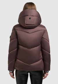 Pruun sulejope kõrge ümarate äärtega kapuutsiga, chevron-mustrilise õmblusega ja tekstureeritud kangaga. Varustatud musta nupu ja elastsete mansettidega.