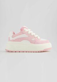 Baskets compensées rose et blanc avec semelle épaisse, empiècements en mesh et cuir, et lacets blancs sur fond gris clair uni.