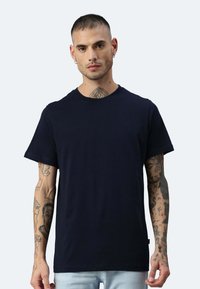 T-shirt in cotone blu navy con collo a giro e maniche corte, caratterizzato da una vestibilità comoda e senza motivi o dettagli visibili.
