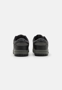 Fekete Nike sportcipők sima bőrből és texturált velúrból készült felsőrésszel, párnázott bokarésszel és halrafonott mintázatú gumitalppal.