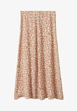 Mujer con un top blanco sin mangas anudado, falda midi de flores naranja, zuecos negros y sosteniendo un bolso blanco tejido.