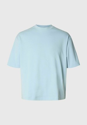 Lyseblå T-shirt med korte ærmer og rund hals, afslappet pasform og ensfarvet design, vist mod en neutral baggrund.