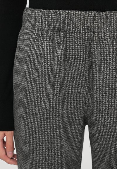 Grau karierte Hose mit elastischem Bund. Der Stoff hat eine weiche und strukturierte Textur. Keine sichtbaren Beschläge oder Akzente.