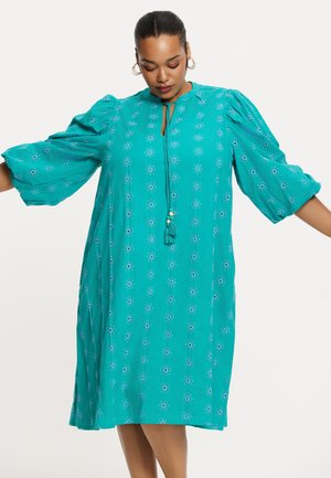 Türkises Kleid mit Puffärmeln und floralem Stickerei. Besitzt einen Ausschnitt mit Knoten- und Quasten-Detail. Lässiger, lockerer Schnitt.