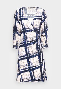 Robe portefeuille avec manches longues bouffantes, poignets froncés, motif écossais abstrait bleu et noir sur fond blanc, nouée à la taille.