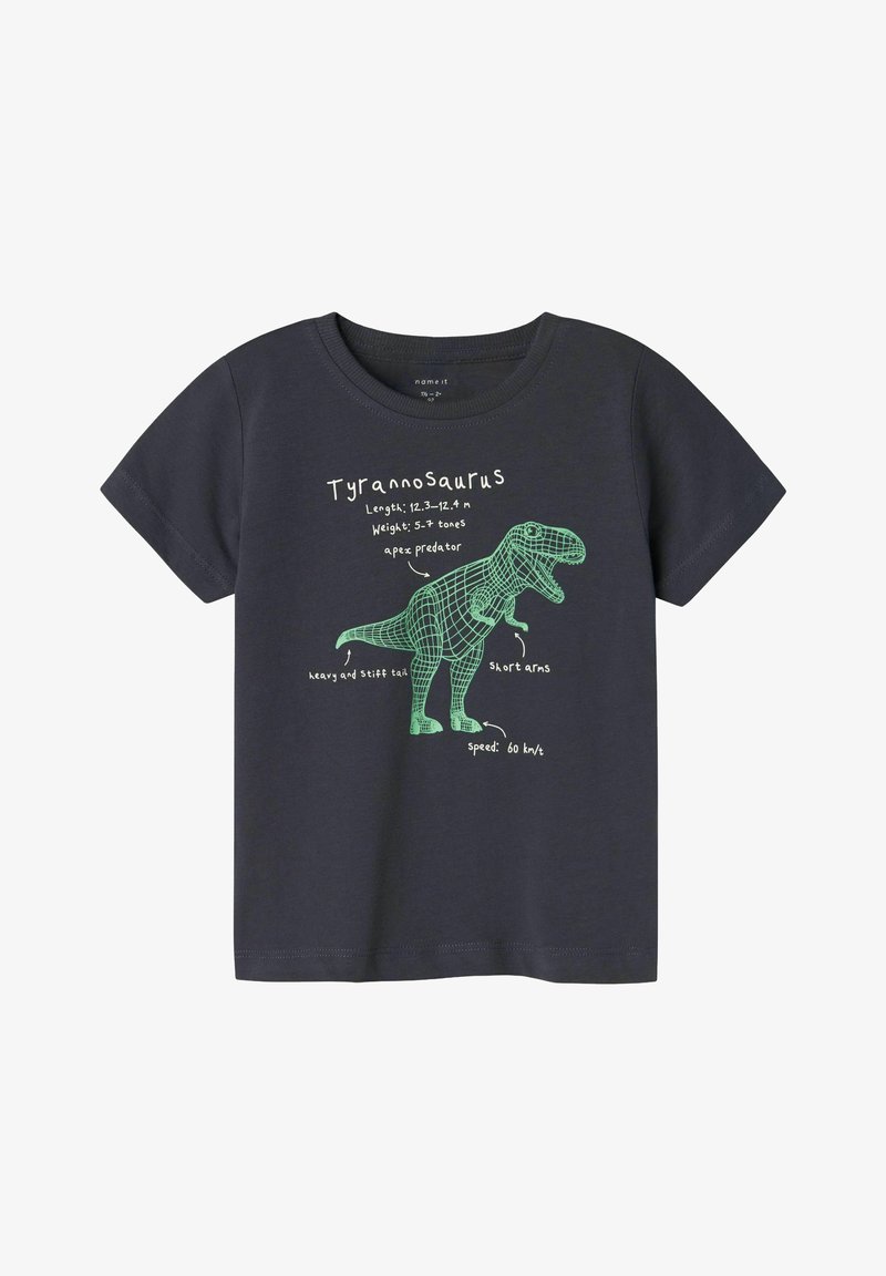 Maglietta a maniche corte grigia scura con una grafica verde di un Tirannosauro che mostra le caratteristiche etichettate. Materiale in cotone con colletto a girocollo.