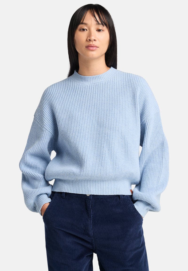 Maglione a coste di un azzurro chiaro con colletto rotondo e vestibilità rilassata. Presenta maniche lunghe e un orlo leggermente accorciato.