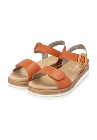 Sandales en cuir orange ouvertes à l'avant avec deux sangles ajustables, un accent tissé circulaire et une semelle plateforme beige avec une bordure blanche.