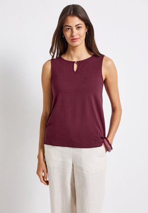 Burgunderfarbene ärmellose Bluse mit Rundhalsausschnitt und Schlüssellochdetail, die an der Taille gedreht ist für einen leicht gerafften Effekt.