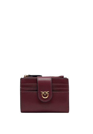 Cartera compacta de cuero rojo oscuro con seis ranuras para tarjetas, un cierre central de presión con dos pájaros dorados en un anillo y un compartimento con cremallera en la parte superior.