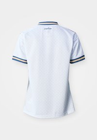 Gaiši zilas īsroku krekls ar tumši zilu un bēšu svītru apmalēm un apkakli, smalks ģeometrisks raksts, "italia" izšūts augšējā muguras daļā.