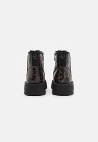 Botines de tobillo de estampado de leopardo negro y marrón con forro de piel sintética, puntera redonda, suela negra gruesa y cierre de cremallera trasera.