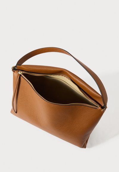 Rjava usnjena torbica za čez ramo z zlato zadrgo, delno odprto, ki razkriva bež notranjo podlogo na belem ozadju.