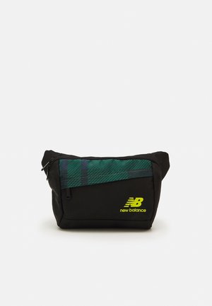 Czarna nerka New Balance z zieloną kratkowaną przednią kieszenią i żółtym logo, pokazana na białym tle.