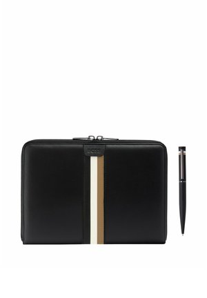 Czarny skórzany portfel zapinany na suwak z pionowymi białymi i beżowymi paskami oraz czarny długopis z podobnymi paskami jako akcentami.