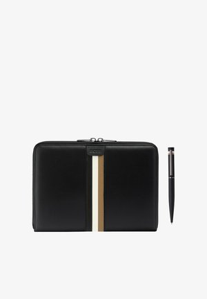 Cartera de cuero negra con cremallera, decorada con rayas verticales blancas y beige, acompañada de un bolígrafo negro a juego con detalles de rayas similares.