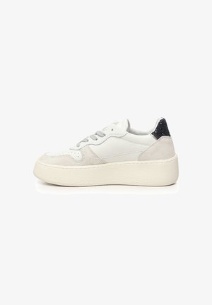 Baskets en cuir blanc avec un design basse, des accents en daim et un talon noir pailleté. Bout arrondi et semelle en caoutchouc blanc texturé.