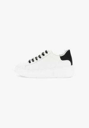 Baskets blanches avec semelle épaisse, lacets noirs et onglet de talon noir, présentées en profil latéral sur fond blanc.