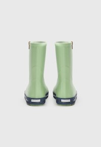 Botas de lluvia de goma verdes con un acabado suave, base azul marino, rayas blancas como acento y pequeñas tiras marrones en la parte superior para facilitar su uso.