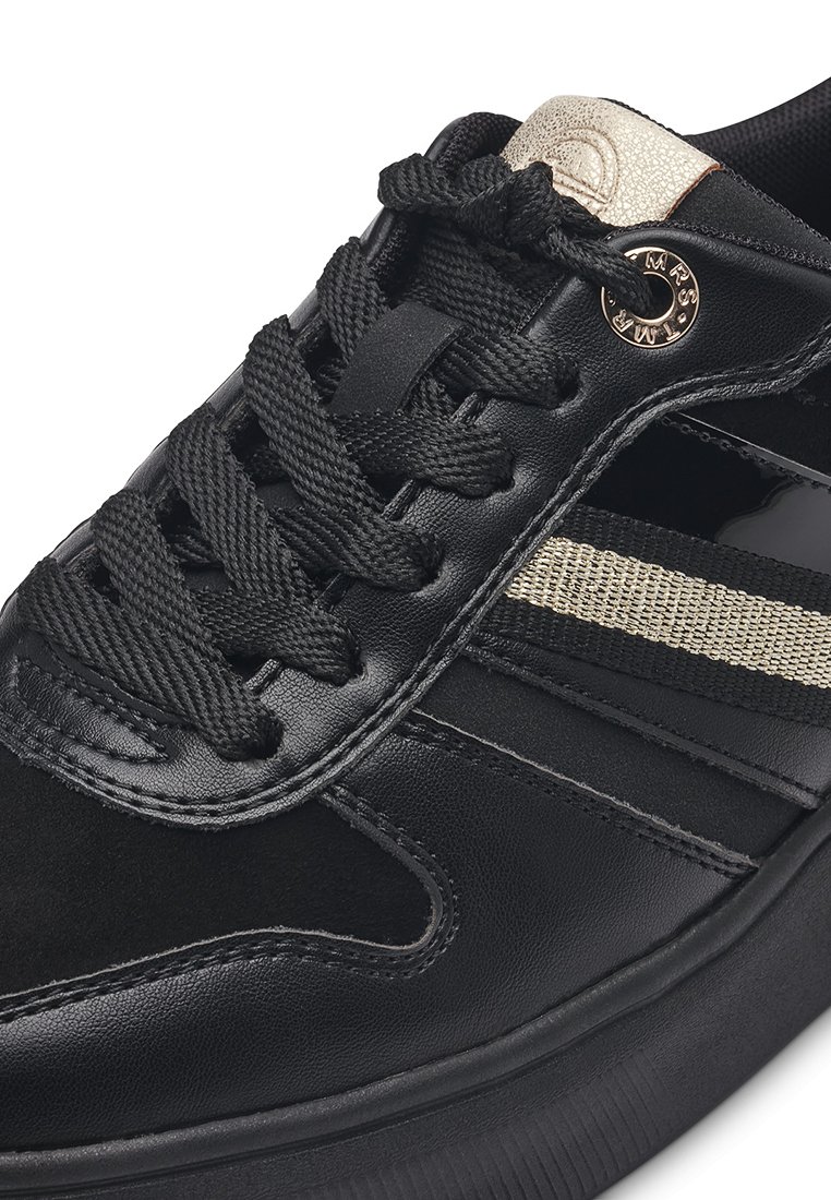 Schwarze Leder-Sneaker mit schwarzen Schnürsenkeln, versehen mit einem strukturierten goldenen Streifen und rundem Metallsymbol an der Seite. Robuste Gummisohle.