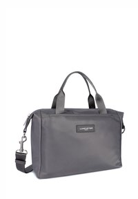 Borsa sintetica grigia con doppio manico e tracolla rimovibile. Presenta una chiusura con zip e una placca con logo sulla parte anteriore.