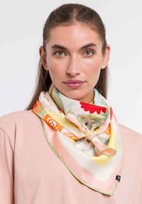 Pañuelo de seda con un colorido patrón floral y de animales, con un borde en rosa y verde, atado en un nudo alrededor del cuello.