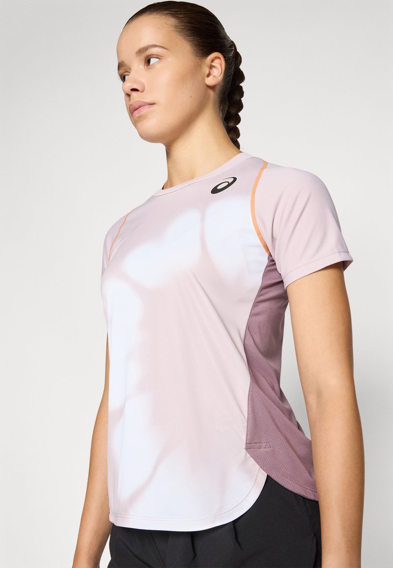 Hellblaues Sportshirt aus feuchtigkeitsableitendem Gewebe mit kontrastierenden dunkelpinken Netzpaneelen und einem dezenten Logo am Kragen.