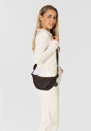 Donkerbruin leren schoudertas met een gebogen silhouet, verstelbare strap en metalen hardware, voorzien van een decoratieve hanger.