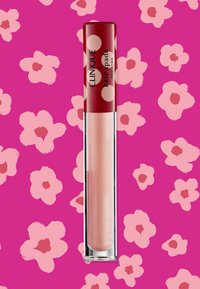 Lucidalucido lip gloss Clinique in un tubetto trasparente con un tappo rosso decorato con pois bianchi. Colore rosa chiaro e lucido con una finitura scintillante.