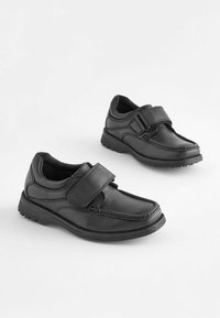 Chaussures en cuir noir avec une sangle auto-agrippante, bout arrondi, côtés texturés et semelle robuste pour l'adhérence. Fini lisse avec des détails de couture.