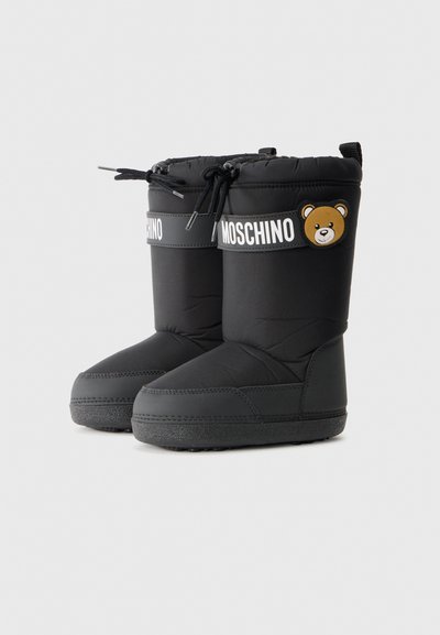 Black insulated boots with a smooth texture, featuring a white branded strap and a bear patch on the side. Round toe and rubber sole.