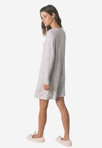 Langærmet grå natkjole med leopardprint-design, lavet af et blødt materiale, har en afslappet pasform og falder over knæet.