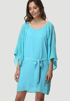 Vestido azul claro de corte holgado, de longitud corta, con mangas de encaje y un cinturón en la cintura. Presenta un escote redondo con detalles decorativos.