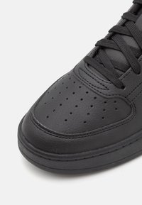 Schwarze Leder-Sneaker mit runder Spitze, strukturiertem Obermaterial, durchlöcherten Details und schwarzen Schnürsenkeln. Gummisohle für zusätzlichen Halt.