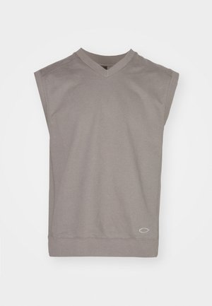 Bez piedurknēm pelēks V veida kakla džemperis ar ribotām aprocēm un mazu ovālu logotipu tuvu apakšmalai, izklāts uz baltas fona.