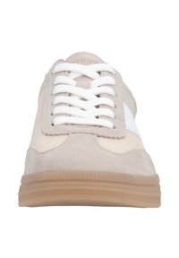 Beige suede sneaker with white accents, flat laces, and a textured rubber sole. Features a rounded toe and a minimalist design.