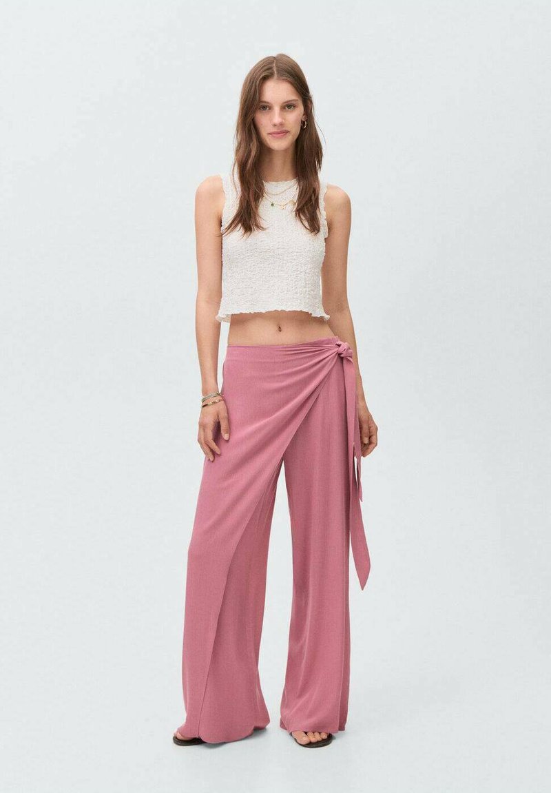 Roze wikkelbroek van lichtgewicht stof, met een gestrikt detail bij de taille, gecombineerd met een witte cropped top met textuur.