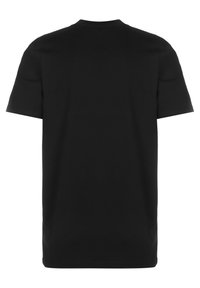 Camiseta negra de manga corta, hecha de algodón, con un diseño clásico de cuello redondo y una textura suave y uniforme. Se muestra la vista trasera.