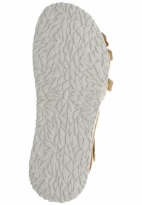 Podeszwa sandałowego buta z teksturowanej, białej gumy, z nierównym, liściastym wzorem zapewniającym przyczepność i trwałość.