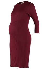 Robe de maternité côtelée bordeaux, avec un col rond et des manches trois-quarts, conçue pour épouser la silhouette autour du ventre.