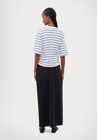 Haut à rayures à manches courtes en coton bleu et blanc, associé à une longue jupe en denim noir avec poches avant et ourlet brut.