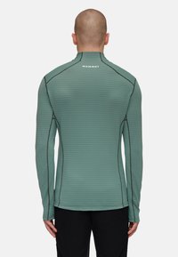 Langsleeve shirt in lichtgroen met horizontale strepen. Heeft contrasterende naden en een hoge kraag, gemaakt van lichtgewicht, rekbaar materiaal.